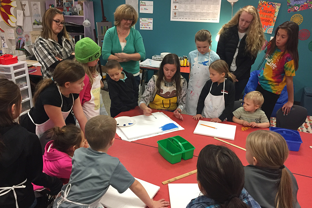 Athlos teacher demonstrates painting technique