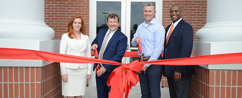 Cutting ribbon in front of the school