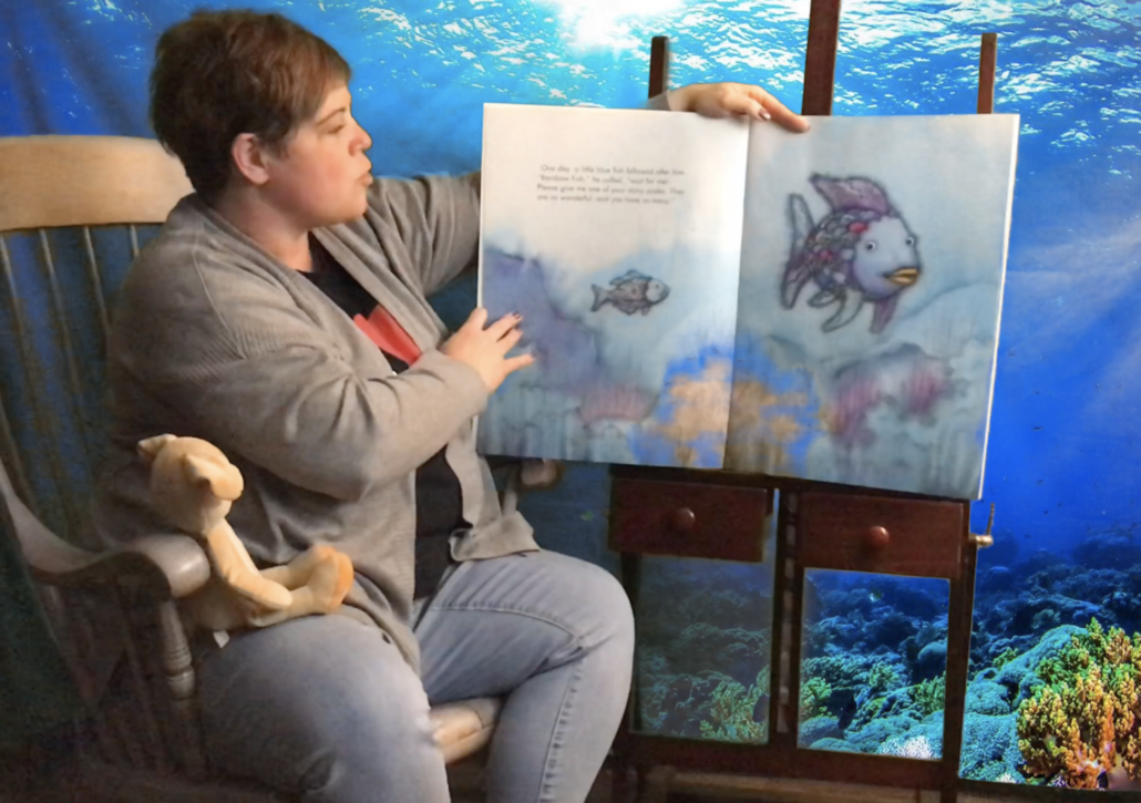 Image of an Athlos teacher reading The Rainbow Fish.